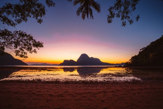 sunset-on-a-tropical-island-with-silhouette-of-pal-2024-10-14-15-38-25-utc-1920px